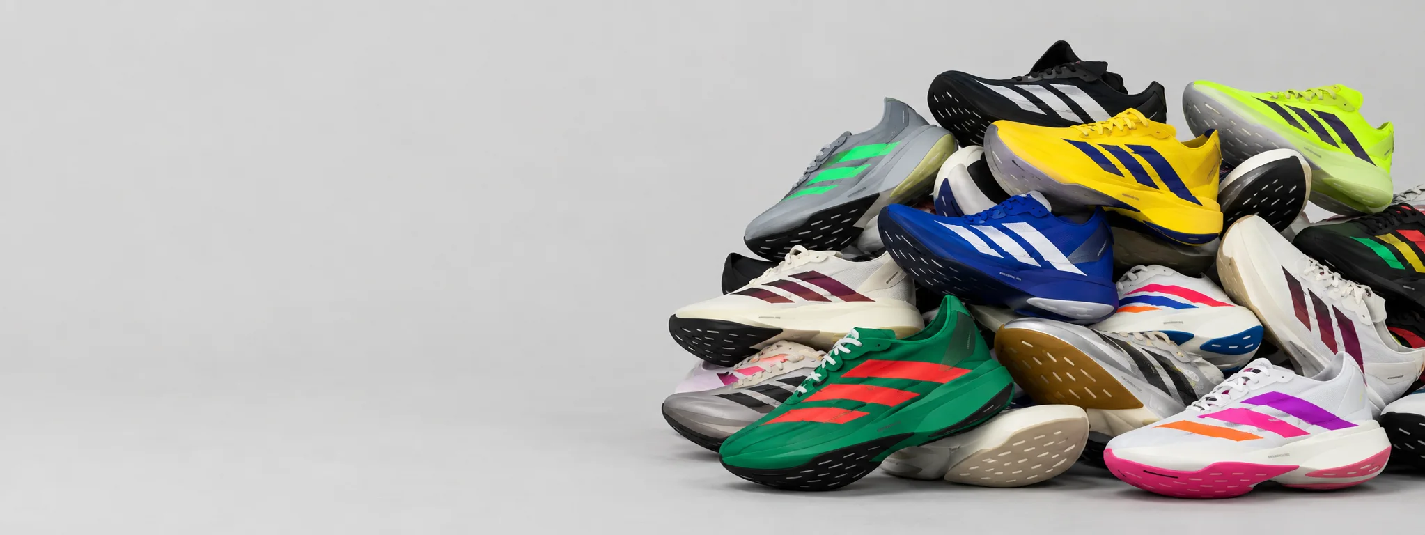 Uma pilha de tênis adidas Adizero de várias cores